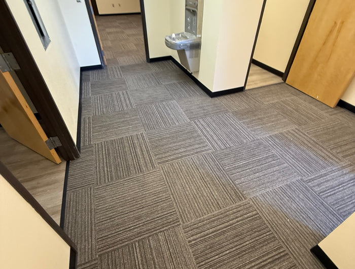 Gray geometric-patterned carpet tiles on a wooden floor