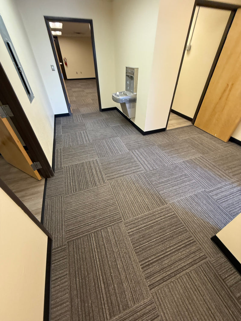 Gray geometric-patterned carpet tiles on a wooden floor
