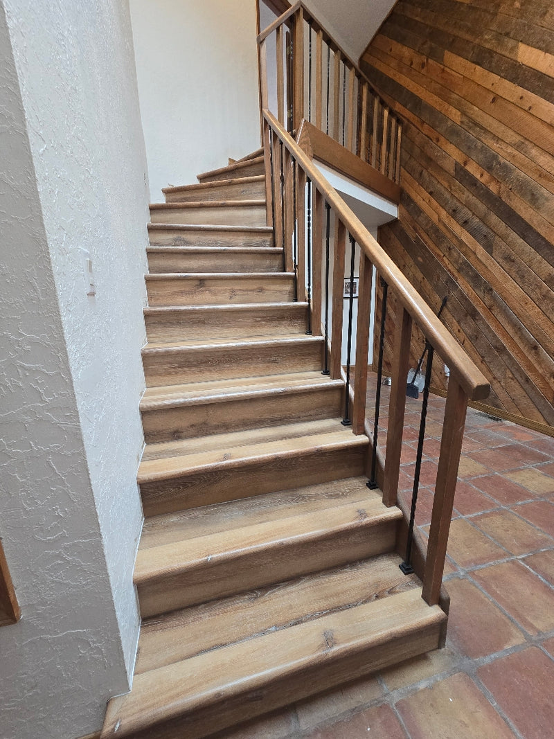 Wooden staircase with a brick wall background