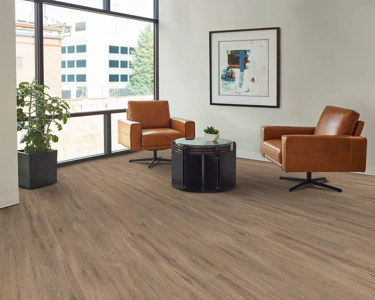 Modern office lobby with brown leather chairs, a black coffee table, and a large window.