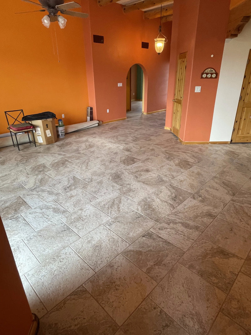 Large room with tiled floor, orange walls, and wooden beams.