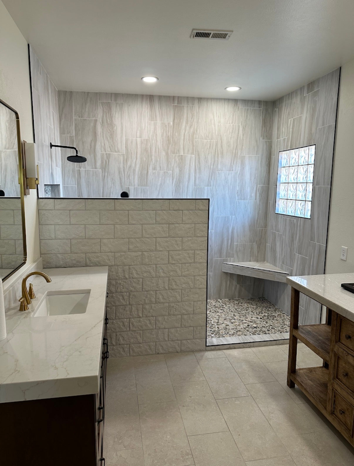 Bathroom with tiled walls, a shower, and a vanity.