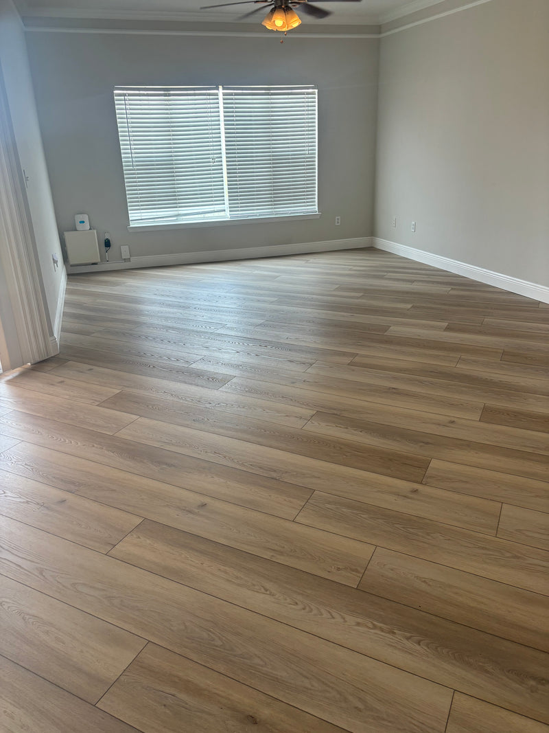 Wooden floor with a gray wall and window in the background